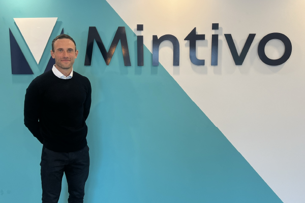 Alex Jukes stood in front of Mintivo sign